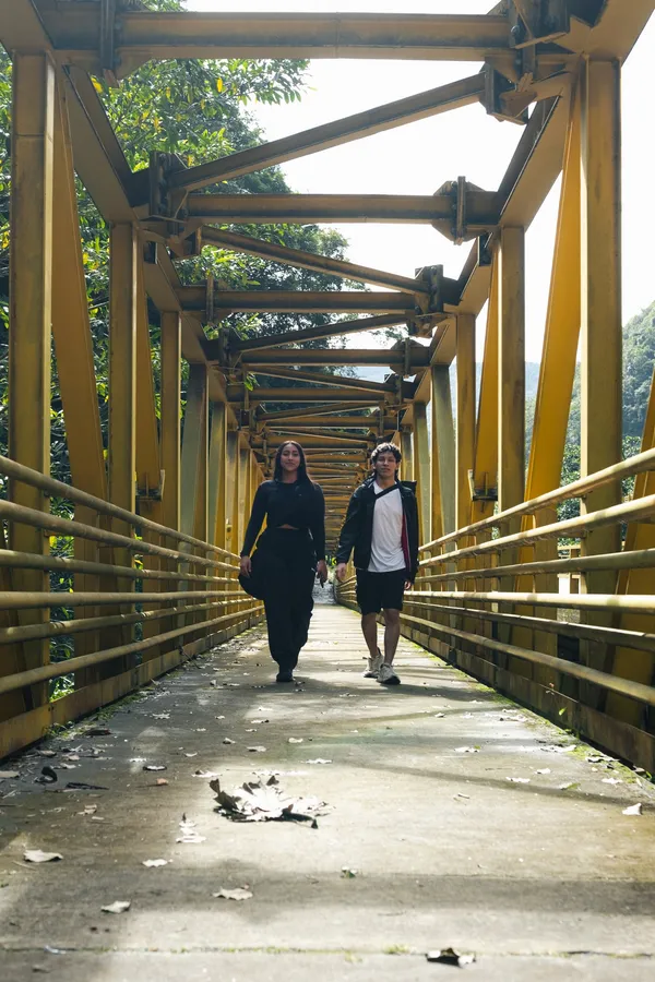 Pareja cruzando el puente amarillo